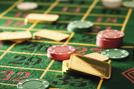 Gambling chips and gold bars on roulette tableの写真素材
