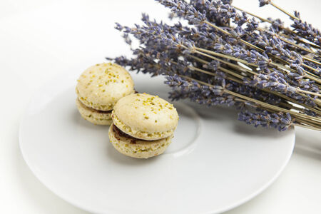 Home-made macaroons on a white plate with lavenderの写真素材