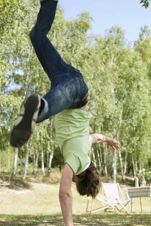 Germany,  Young man performing handstand on one hand