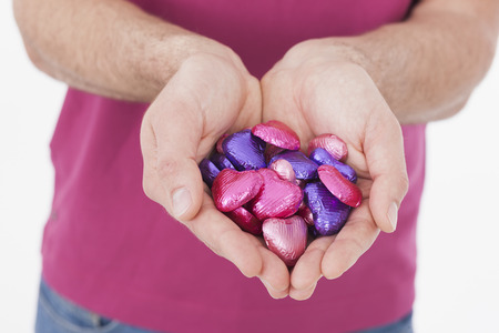 adult man holding heart shaped sweetsの写真素材