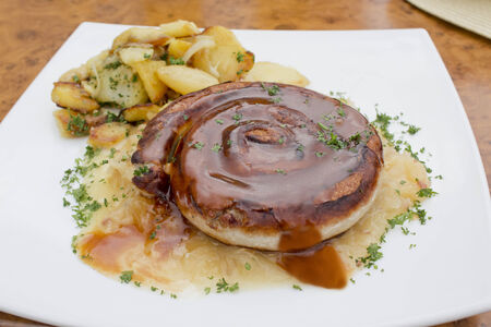Grilled coiled sausage with sauerkraut and roast potatoesの写真素材