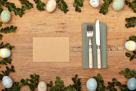 Easter decoration, blank, card, napkin, knive and fork on woodの写真素材