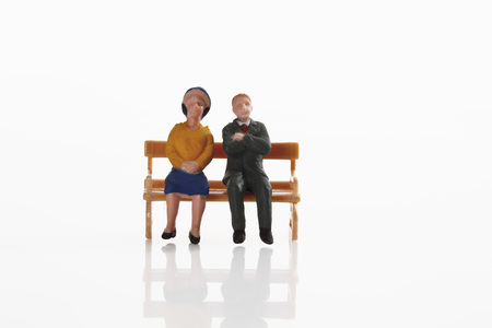 Retired couple figurine resting on benchの写真素材