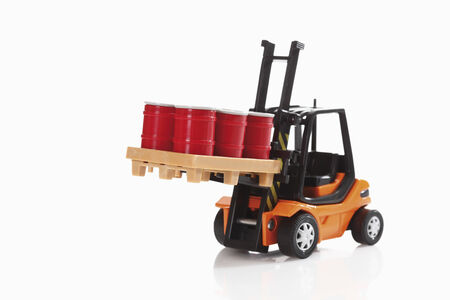 Toy forklift truck carrying barrels on white background