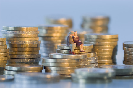 Couple figurines sitting on coin tower and kissingの写真素材