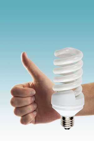 Hand shown thumbs up sign with lightbulb, close upの写真素材