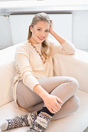 woman sitting with her legs up on a sofaの写真素材