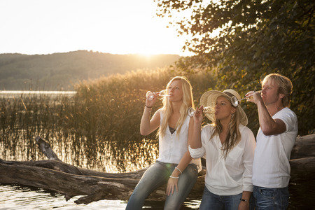 Couple with daughter drinking champagne at lakeの写真素材