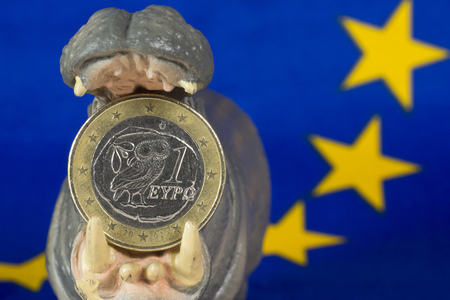 Greek one euro coin in mouth of hippo figurineの写真素材