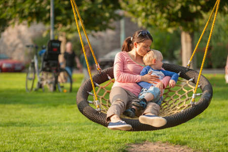 Germany, Leutesdorf, Mother and son on swingの写真素材
