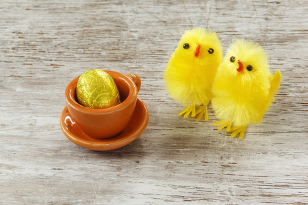 Eastern, chick figurines and easter egg in cup on wood