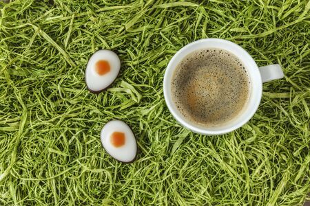 Eastern, coffee cup and fondant eggs on artificial grassの写真素材