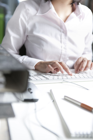 Woman working at desk, keyboardの写真素材