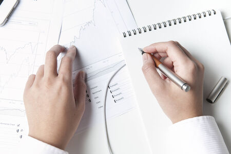 Stockbroker writing on notepad