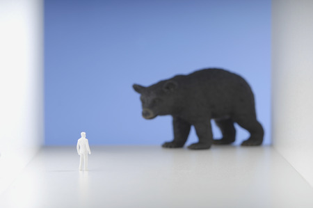 Figurine standing in front of bear.の写真素材