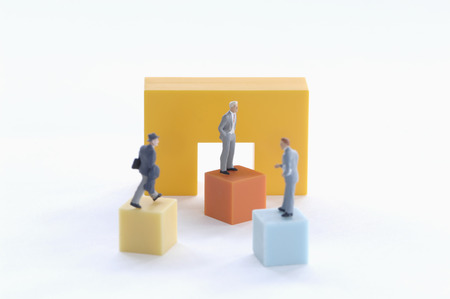 Businesspeople figurines on a podium.