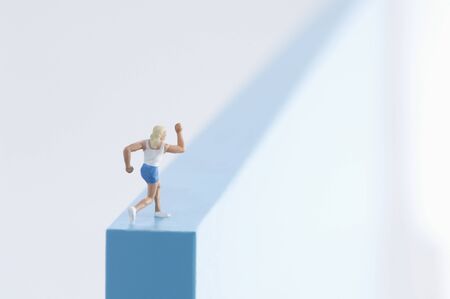 Woman figurine running on a blcck.