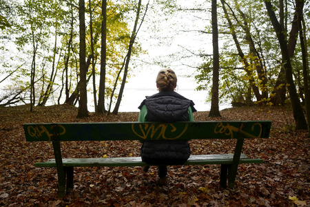 Germany, Berlin, sad young woman sitting on benchの写真素材