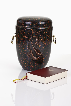 Urn and bible on white backgroundの写真素材