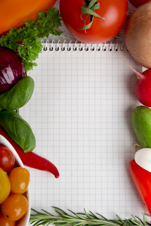 Notepad, fresh vegetables and herbsの写真素材