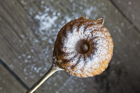 Ring Cake with icing sugar on pastry fork, woodの写真素材
