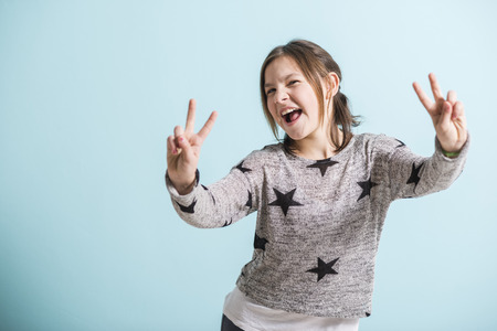 happy young girl showing victory signの写真素材