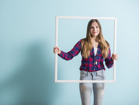 Young girl looking through picture frameの写真素材
