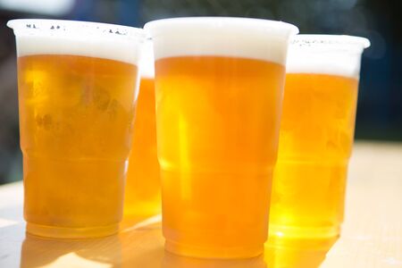 Fresh beer in plastic glassesの写真素材