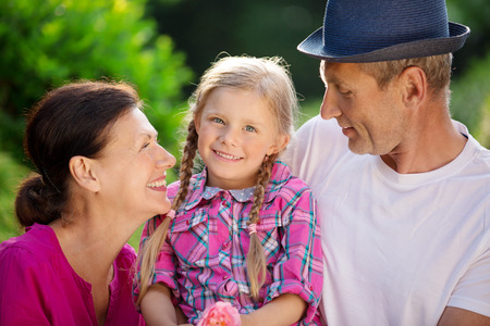 Girl with father and granny in garden