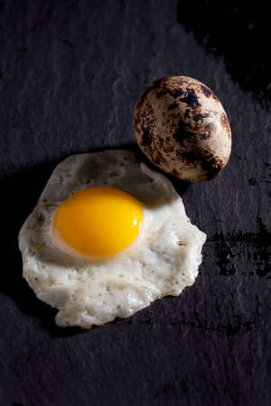 Fried quail egg on slate, quail eggの写真素材