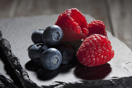 Raspberries and blueberries on slateの写真素材