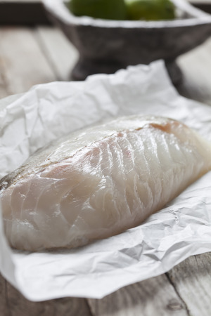 Row fish fillet, cod on greaseproof paperの写真素材