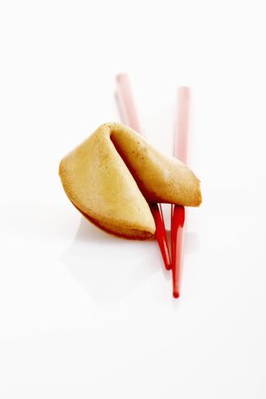 Fortune cookie and chopsticks on white backgroundの写真素材