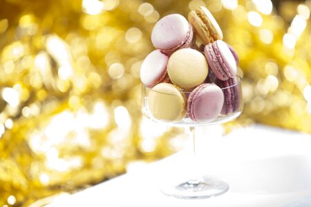 Macarons in glass, golden backgroundの写真素材