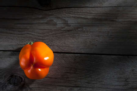 Orange paprika on dark woodの写真素材