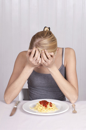 Anorectic woman, plate with spaghettiの写真素材