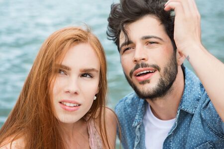 Young couple at lake looking up
