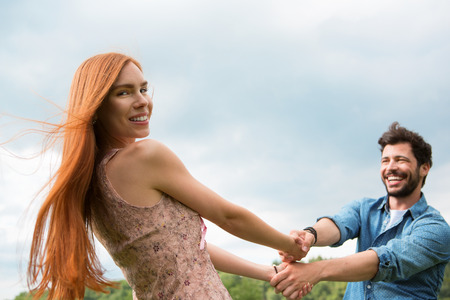 Happy young couple whirling aroundの写真素材