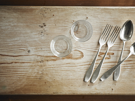 Cutlery and tableware on wooden board