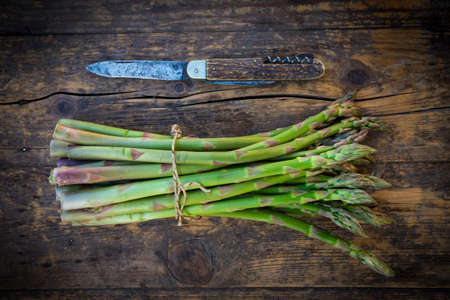 Organic green asparagus and pocket knifeの写真素材