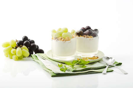 Low-fat yoghurt with cornflakes and grapes in glassesの写真素材
