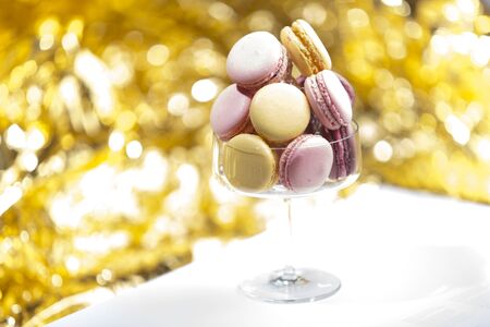 Macarons in glass, golden backgroundの写真素材