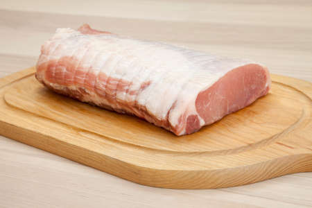 Raw rolled pork roast on chopping boardの写真素材