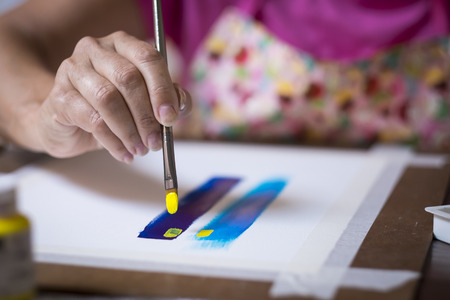 Close up section of female painter artist - hand leading brush. Woman painting a pictureの写真素材