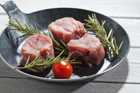 Bacon wrapped pork fillet with tomatoes in panの写真素材