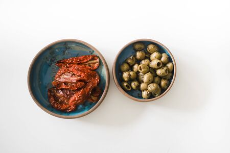 Dried tomatoes and olives on turqouise platesの写真素材