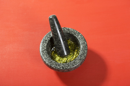 Fresh pesto Genovese in mortar on redの写真素材