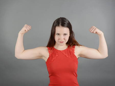 Young woman flexing muscles