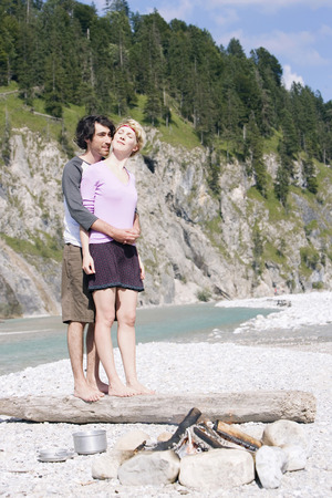 Germany, Bavaria, TÃ¶lzer Land, Young couple standing on tree trunkの写真素材