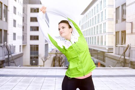 Young woman jogging in the city, warming up